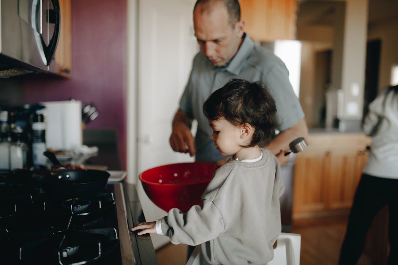 Father and child enjoying a cooking session together in the home kitchen.